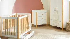  A sweet baby's room adorned with pink walls and stylish wooden furniture, ideal for nurturing and play.